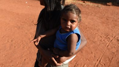 A young mother walks with her child at the Mutitjulu aboriginal community, at the foot of Uluru, also known as Ayres Rock, in the Northern Territory,