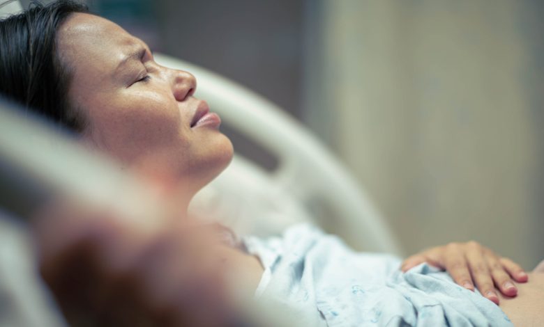 A sick woman patient in bed at the hospital suffering from pain. Contractions and childbirth.