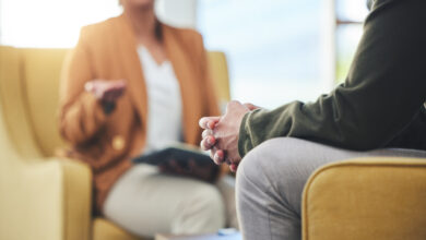 Man, hands and listening for therapy, sofa or advice from woman for mental health, psychology or care. Psychiatrist, patient and frustrated in clinic, session or couch for help, anxiety or depression