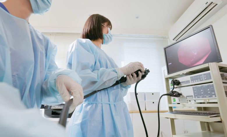 Closeup low angle view asian physician colonoscopy to patient in the clinic with nurse assistance - cancer related examinations