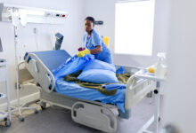 Female cleaner changing bed sheets at the hospital room