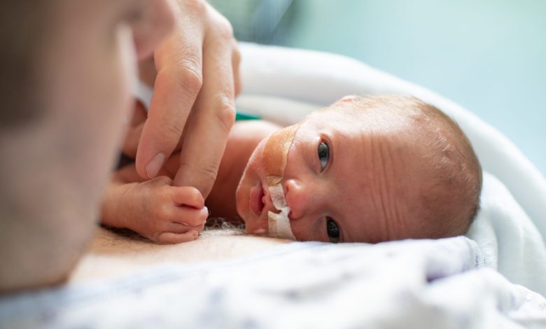 Father taking care of his premature baby doing skin to skin at hospital. Color and horizontal photo was taken in Quebec Canada.