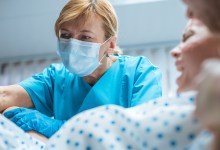 In the Hospital Close-up Shot of Professional Midwives work Assisted by Obstetricians. In Modern Delivery Woman Pushes to Give Birth
