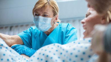 In the Hospital Close-up Shot of Professional Midwives work Assisted by Obstetricians. In Modern Delivery Woman Pushes to Give Birth