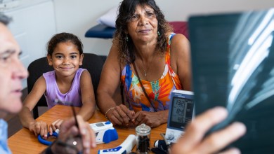 Young Aboriginal girl and her Grandmother consult with their Pacific Islander doctor about her ultrasound results in his office