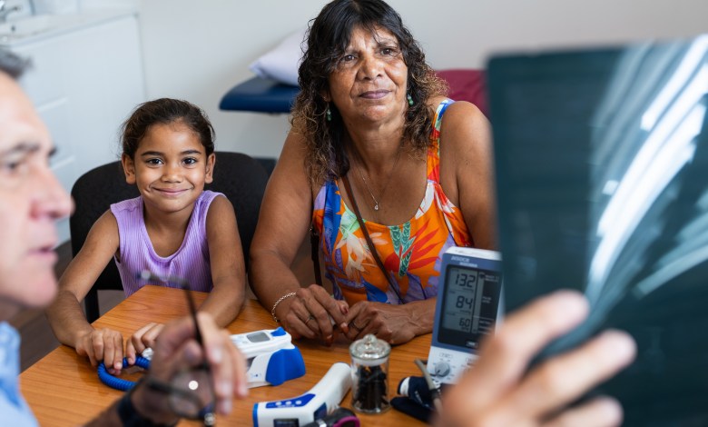 Young Aboriginal girl and her Grandmother consult with their Pacific Islander doctor about her ultrasound results in his office