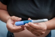 Person's hands holding an insulin pen for diabetes treatment
