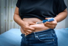 Person injecting insulin into their stomach for diabetes management