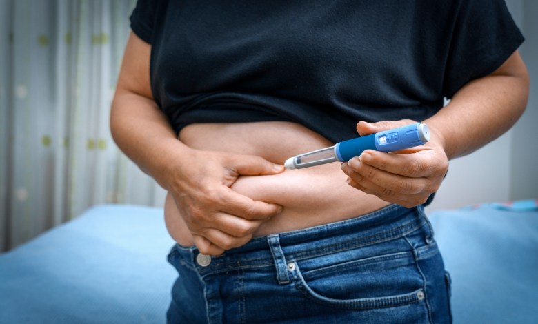 Person injecting insulin into their stomach for diabetes management